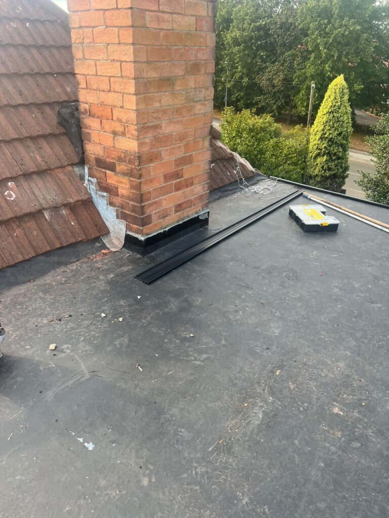 This is a photo of a flat roof which has just been repaired, there is also a chimney stack and some leadwork has also been dressed. Works carried out by TRP Roofing Kingswood